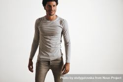 Smiling man in grey shirt and jeans on a blank background 5wl1v4