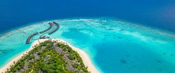 Wide aerial shot of beach resort with blue tropical waters