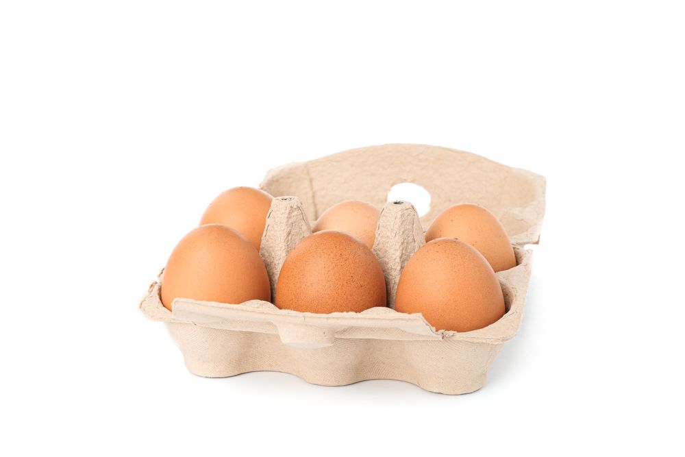 Brown chicken eggs in carton box isolated on blank background