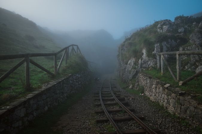 Old railway leading into mysterious foggy valley