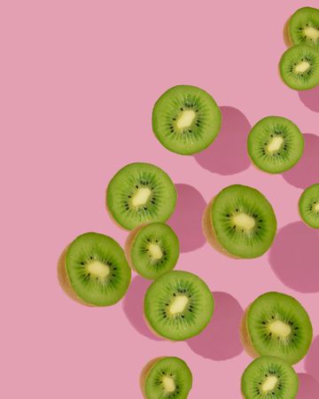 Fresh green kiwi flying in a pink background