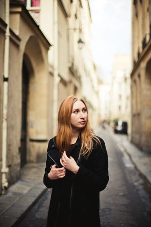 Woman standing in an alley looking away
