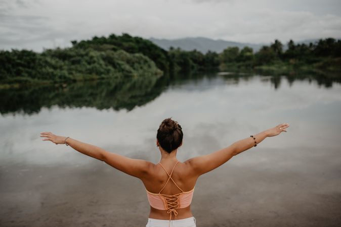 Unrecognizable woman enjoying freedom near lake