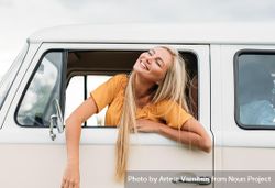 Woman leaning out of car window looking up and smiling 498nn5