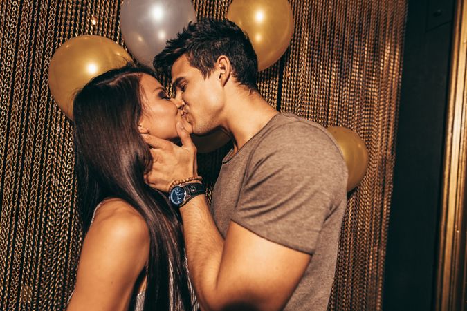 Young man and woman kissing in nightclub