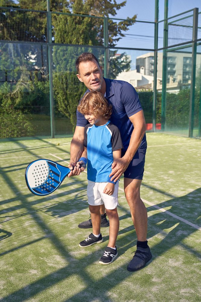 Coach and boy exercising with racket