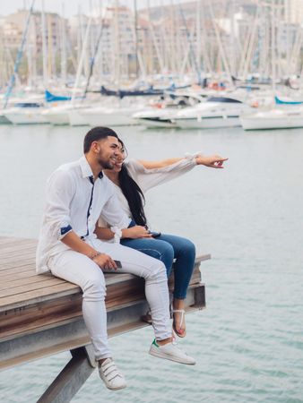 Man and woman sitting on dock with feet