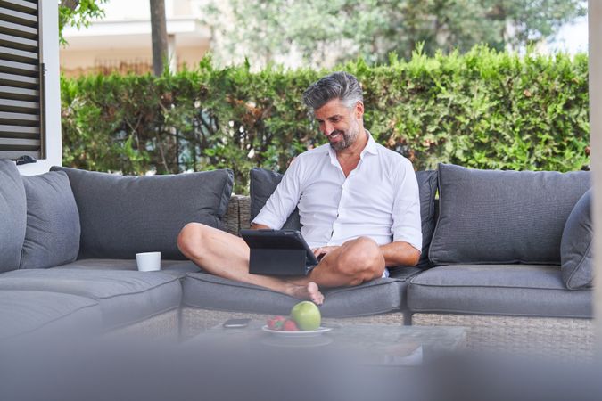 Businessman working on tablet in backyard