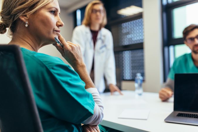 Female medical professional in meeting with colleagues
