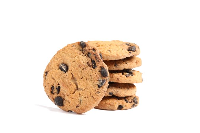 Stack of tasty chocolate chip cookies on plain background