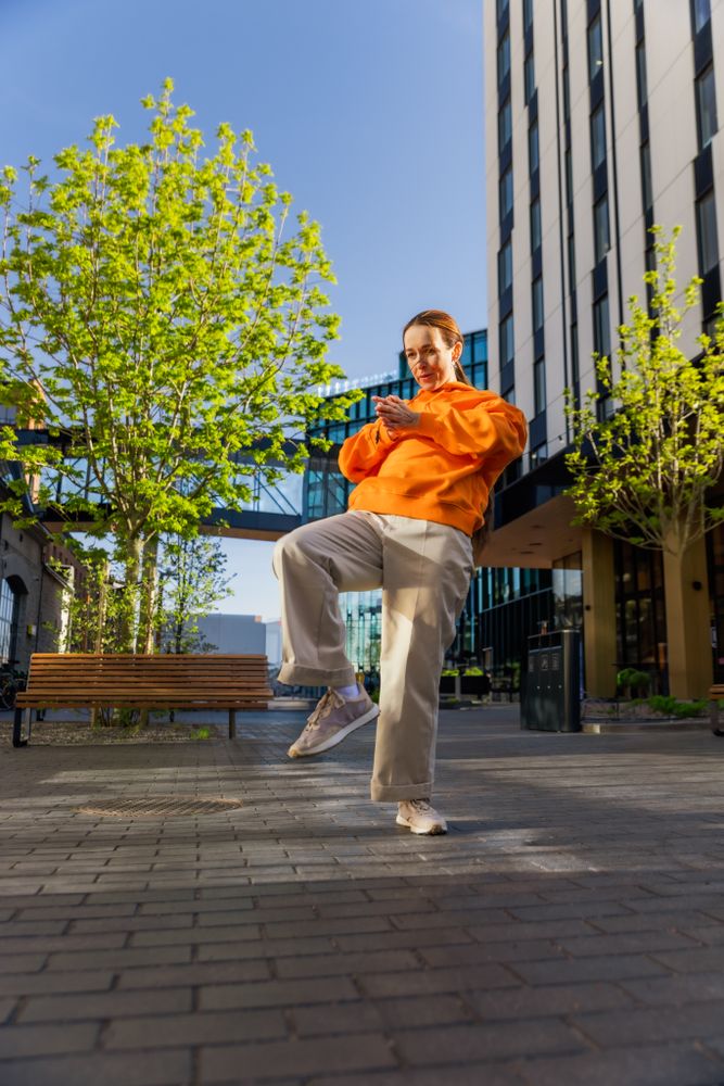 Vertical Screen: Young And Stylish Female Hip Hop Dancer Freestyling On City Street Among Modern Buildings.