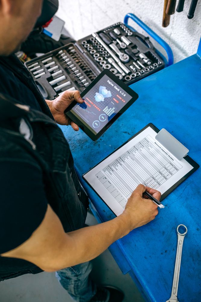 Mechanic using tablet app and taking notes