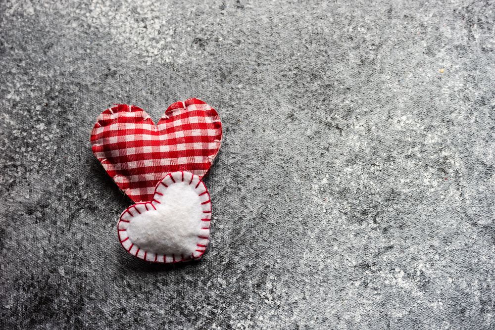 Valentine's day concept with two red felt hearts on grey counter