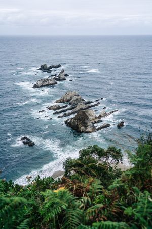 Rocky peaks surrounded by foamy water in windy day