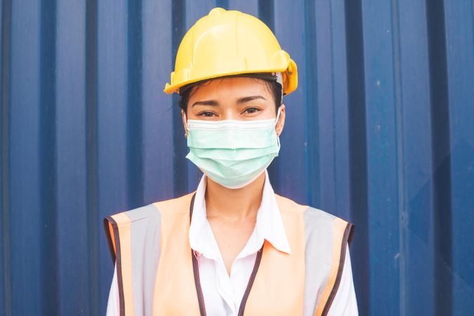 Portrait of female Asian logistic engineer wearing protective mask looking at camera