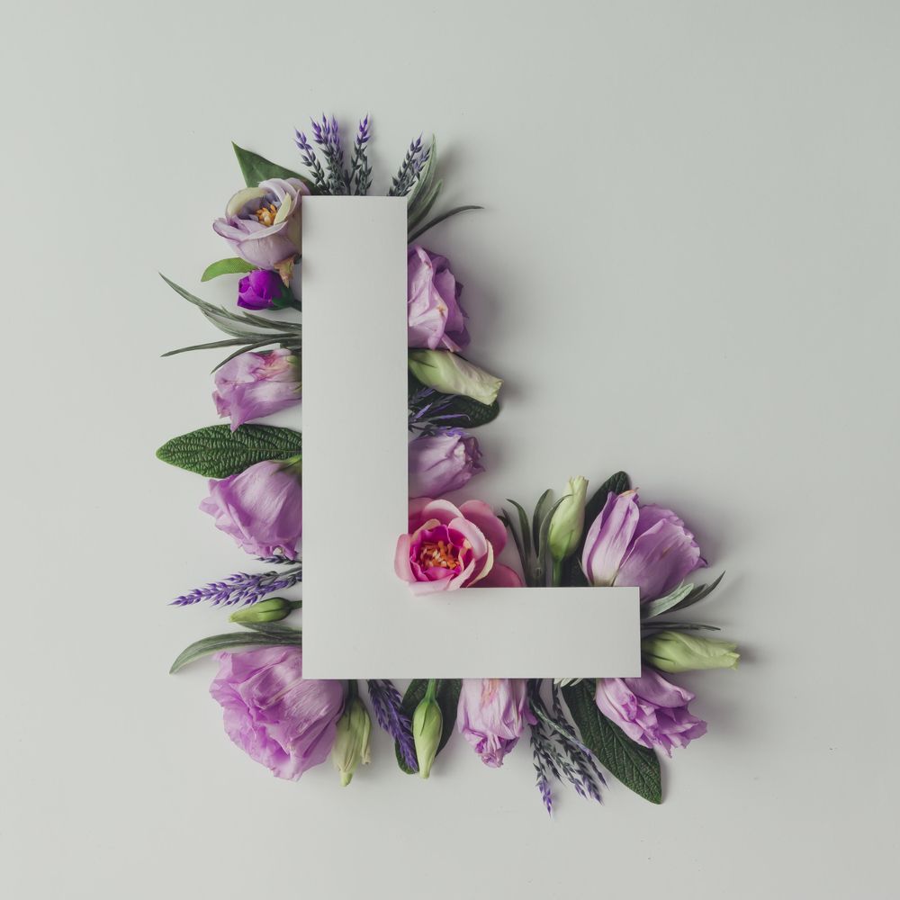 Colorful flowers, leaves and paper “L”