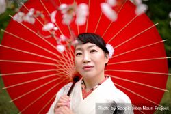 East Asian woman in light kimono holding a red umbrella 47qjB0
