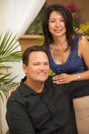Loving Hispanic and White Couple In Front Of Fern