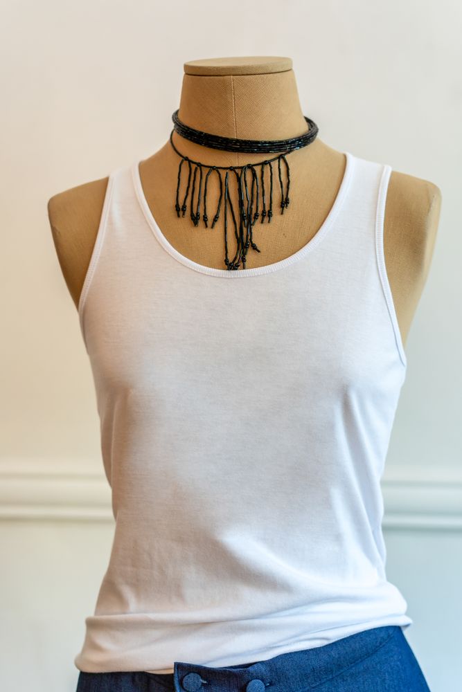 A mannequin dressed up with a white tank top. Stylish and fashion concept