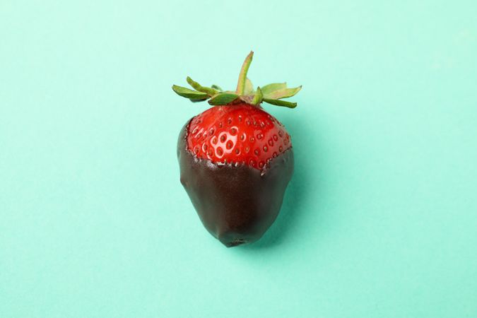 Chocolate fondue. Strawberry in chocolate on mint background