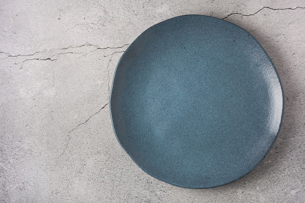 Empty plate on the slate table. Top view of the image.