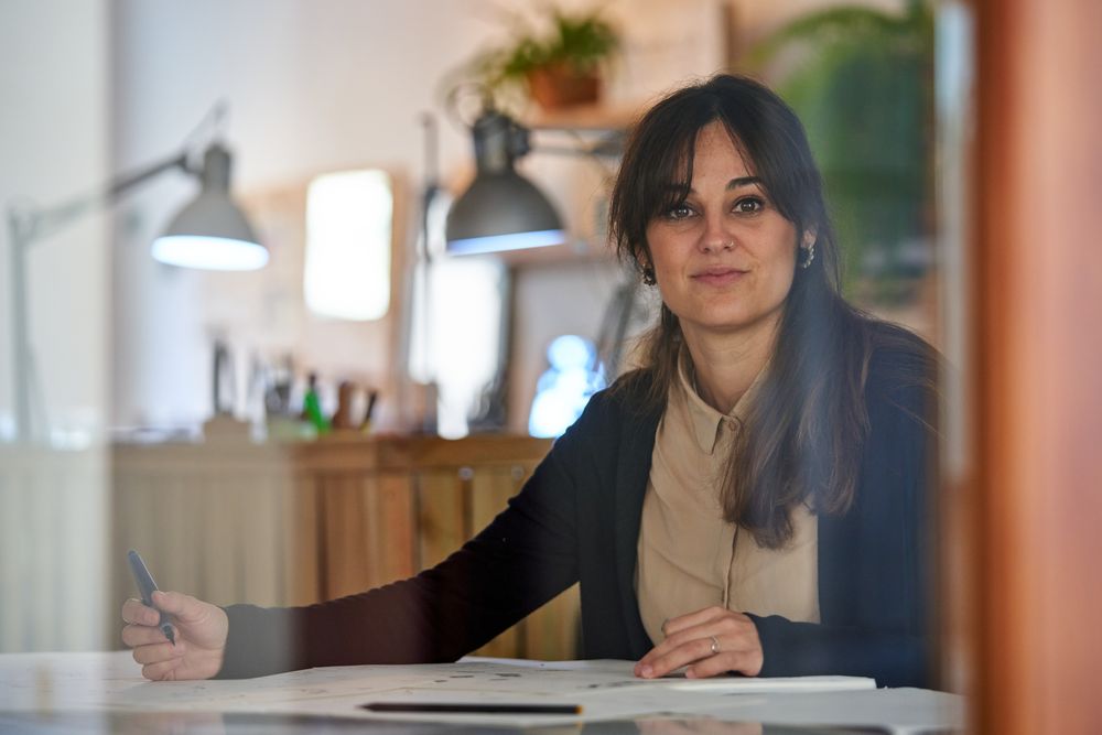 Craftswoman creating design on papers in workshop