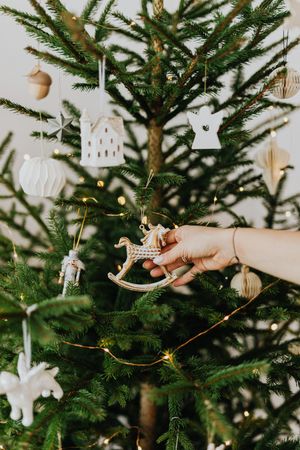 Cropped image of a hand decorating a Christmas tree with ornament