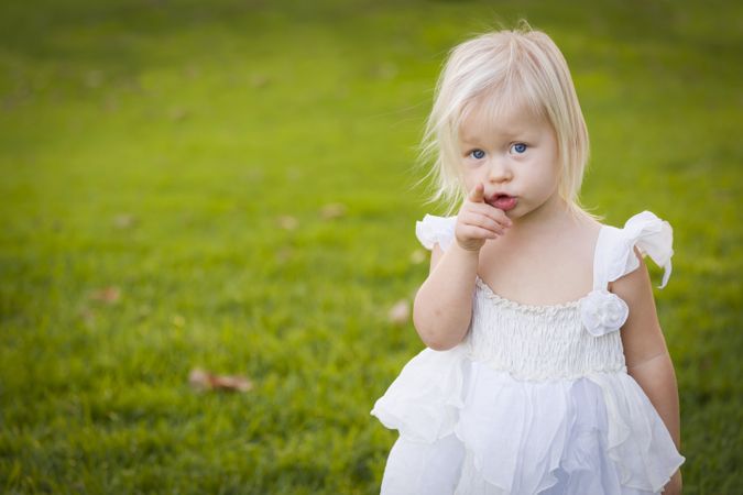 Adorable Little Girl Wearing Dress In A Grass Field