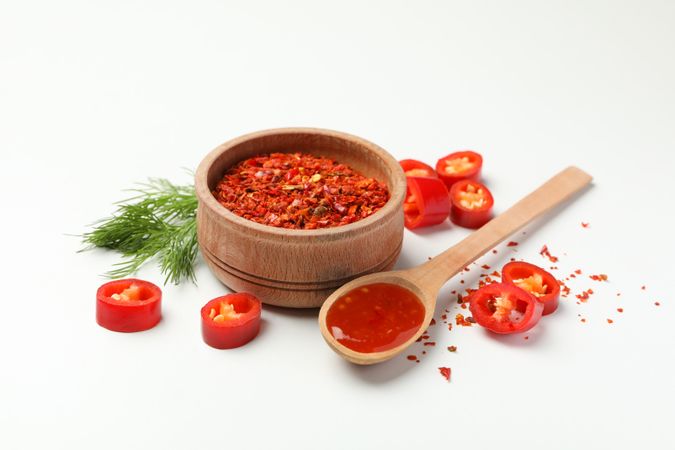 Composition with chilli pepper, spice and sauce on studio background