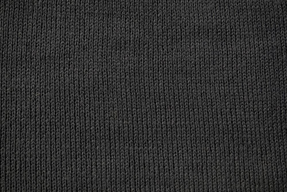 Detailed dark grey knitted fabric background texture.