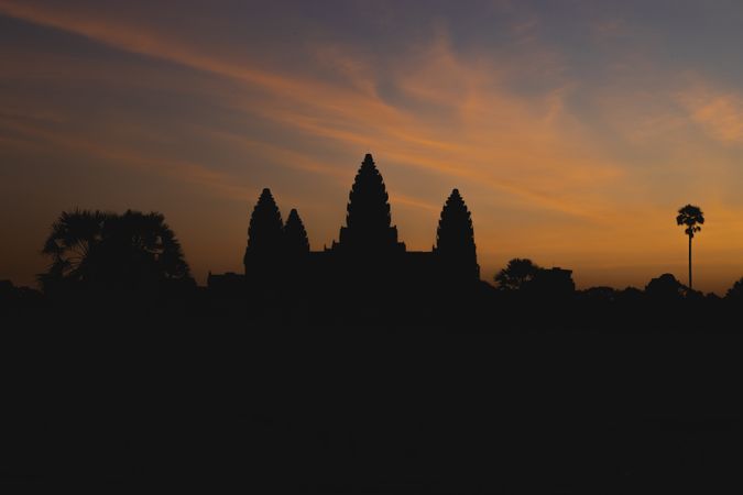 Dawn slowly rises over Angkor Wat, as the orange light reveals the silhouette of the main temple