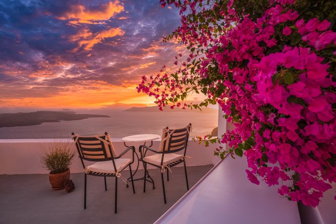 Dynamic sunset over the Aegean Sea with patio chairs on deck