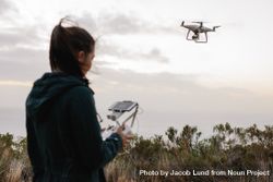 Woman operating a drone against a cloudy sky bxGra4