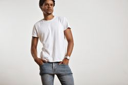 Man with hands in jean pockets looking at camera in studio shoot