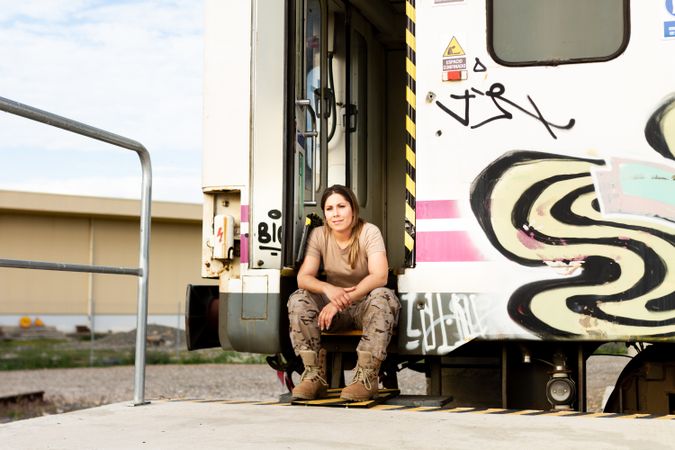 Military woman sitting near van