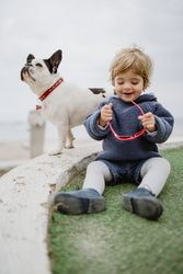 Funny kid with dog on beach