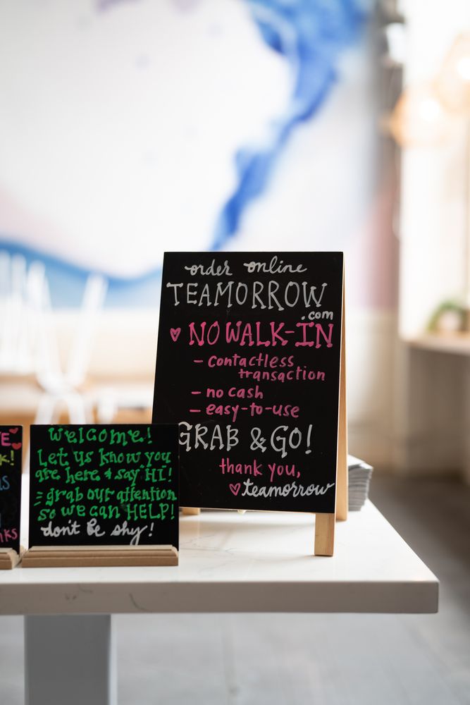 Hand written chalkboard sign in restaurant requiring take out only service