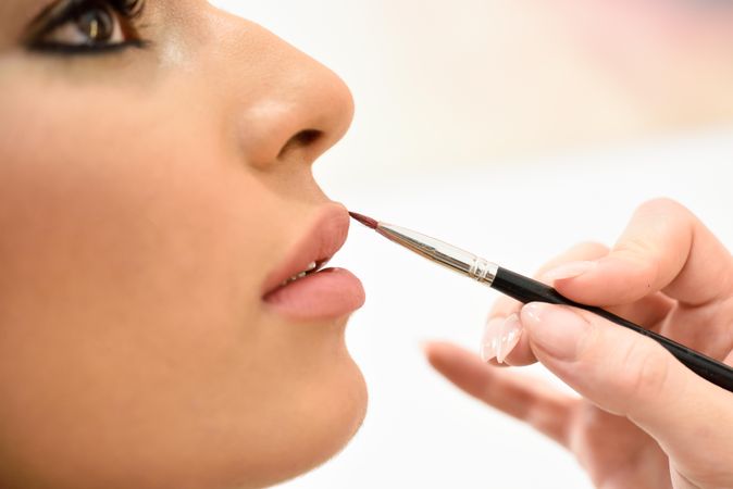 Woman having lipstick applied by a professional MUA