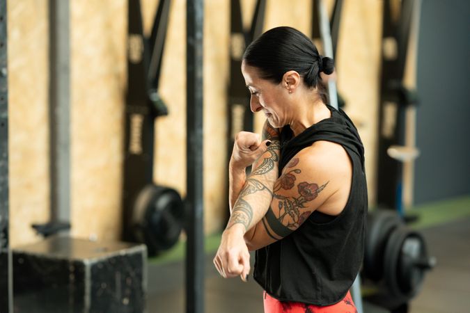 Tattooed woman stretching before workout