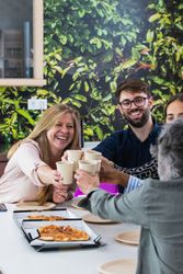 Diverse colleagues having lunch together in kitchen of office