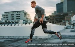 Male athlete doing drag running on rooftop 0LQng5