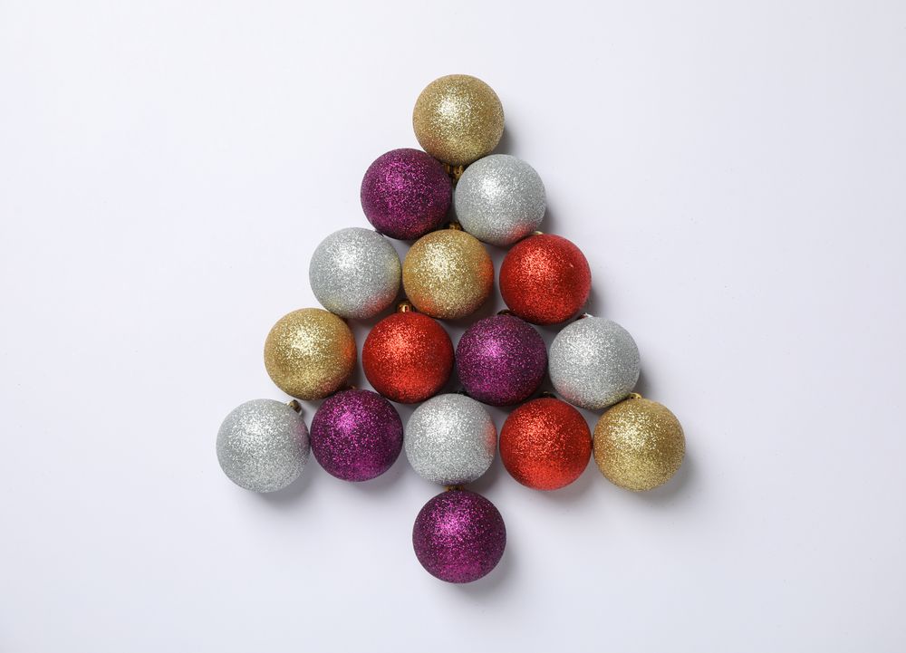 Christmas tree made of baubles on light background, space for text