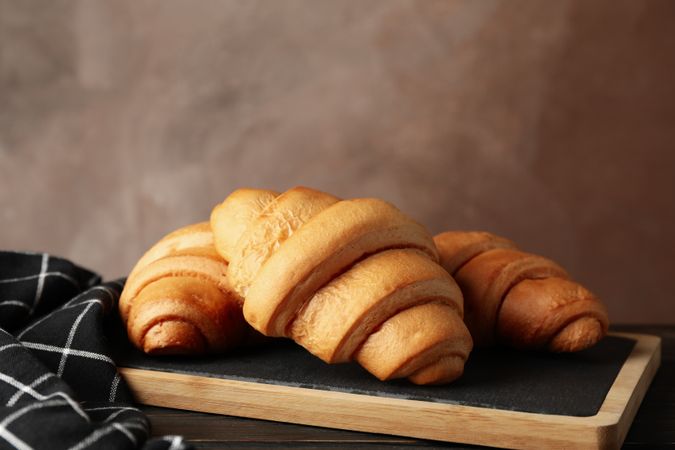 Side view of pastries on breadboard, copy space