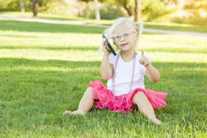 Little Girl In Grass Talking on Cell Phone