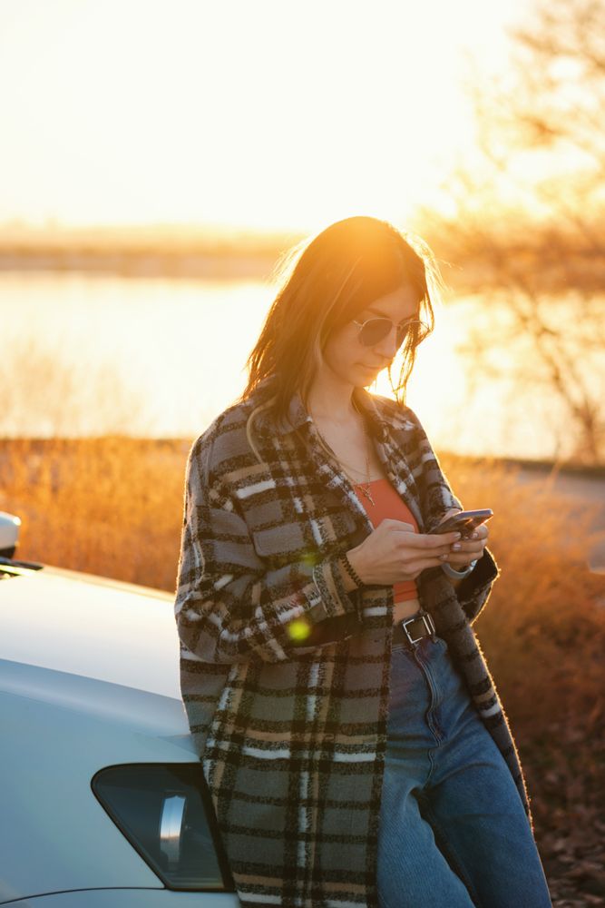 Woman near car use mobile app map