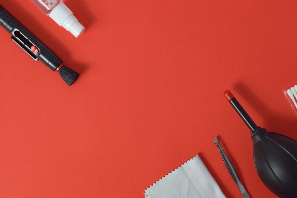 Top view of lens cleaning kit on red table with copy space