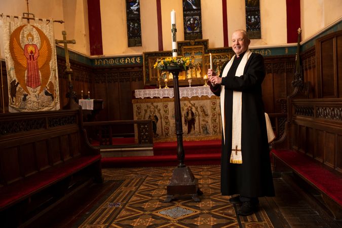 Vicar with candle in church