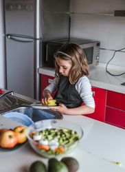 Girl washing dishes in kitchen