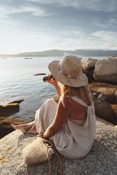 Woman relaxing and drinking beer at beach
