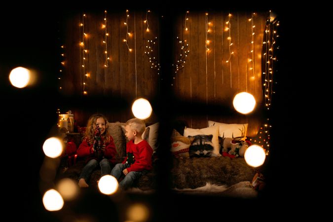 Siblings playing in a room with christmas decoration